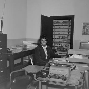 black and white image of a women sitting in her office
