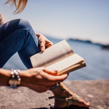 women reading book on a beach