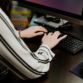 female hands and child hands typing on laptop keyboard