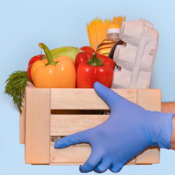 gloved hands carrying box with fresh produce