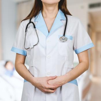 women nurse standing with hands folded