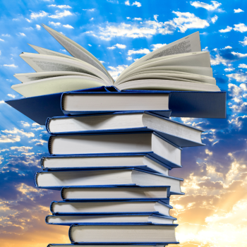 A stack of blue books in front of a beautiful sunrise.